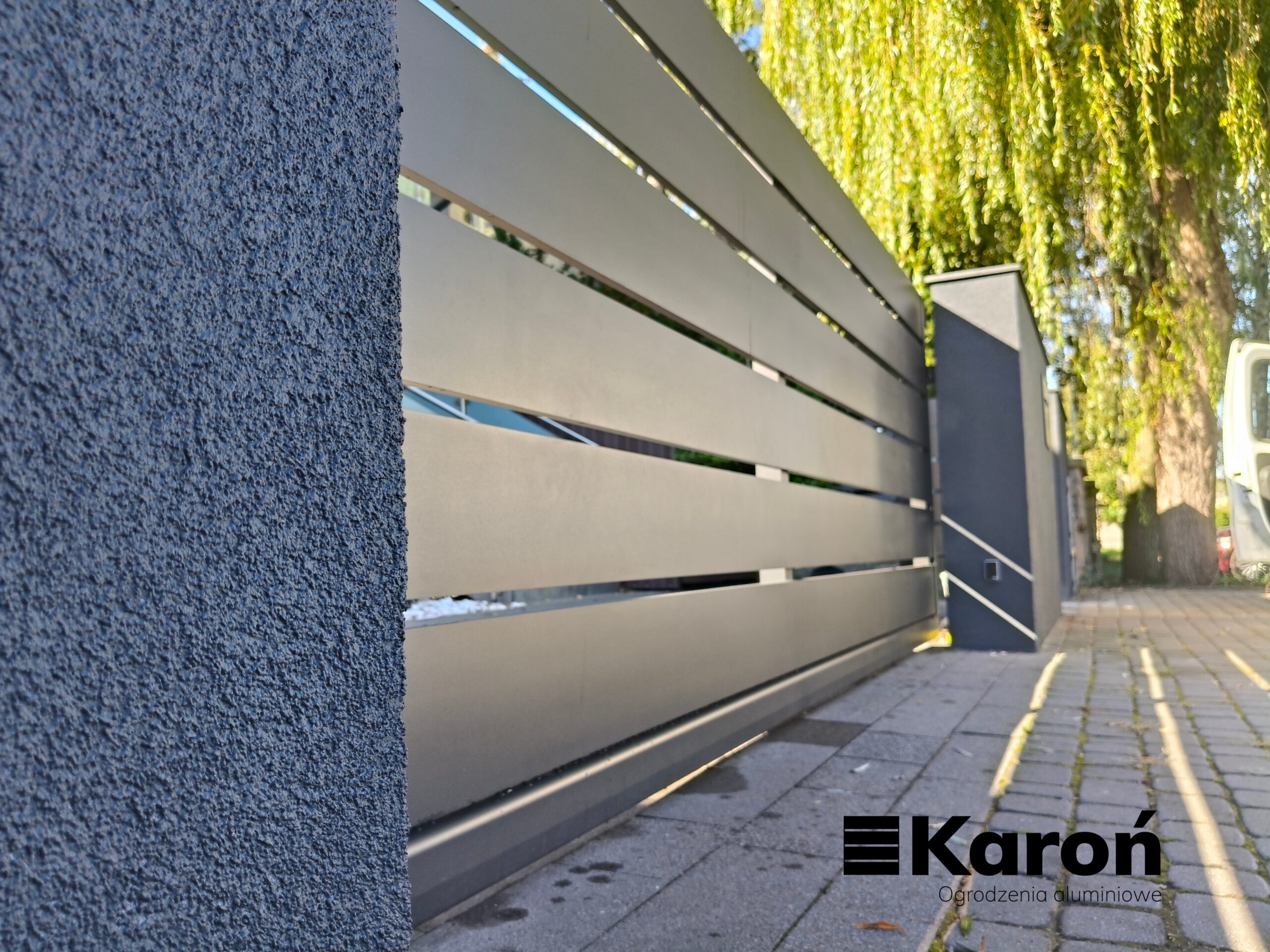 Brama przesuwna aluminiowa z szerokich profili w ciemnym kolorze – realizacja Łódź